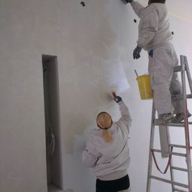 Maler bei Malerarbeiten einer Wand für Malerei in Villach-Land in Kärnten