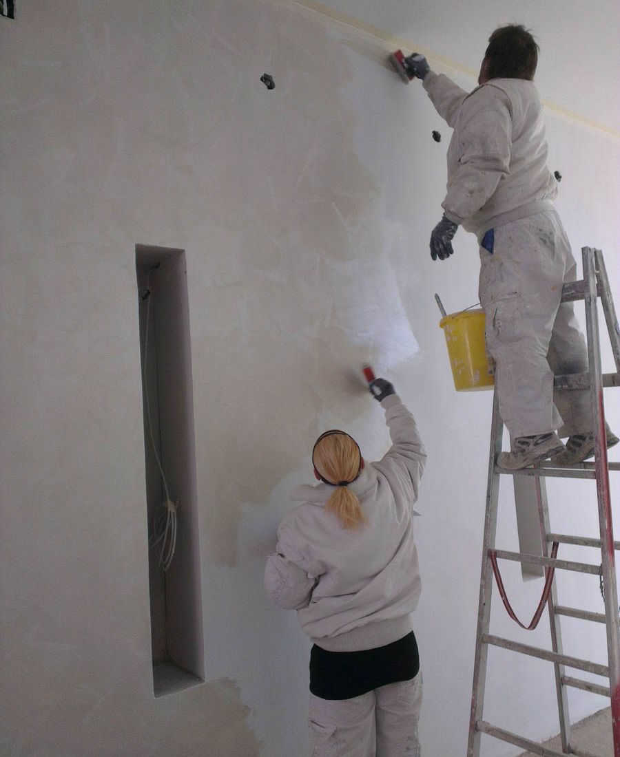Maler bei Malerarbeiten einer Wand für Malerei in Villach-Land in Kärnten